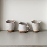 White cups and mug in a row