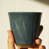 Blue handmade stoneware ceramic cup with prehistoric lines around by Sticky Earth Ceramics SG