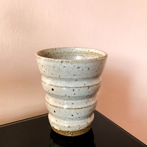 A creamy white speckled cup with wide horizontal grooves by Sticky Earth Ceramics SG