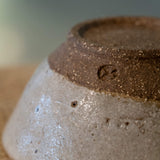 Close up image of Sticky Earth Ceramics SG speckled white bowl's rough bottom texture